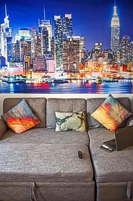 a couch with a view of a city at night at Spacious Cozy Retreat, Sleeps 10, Near NYC & EWR in Newark