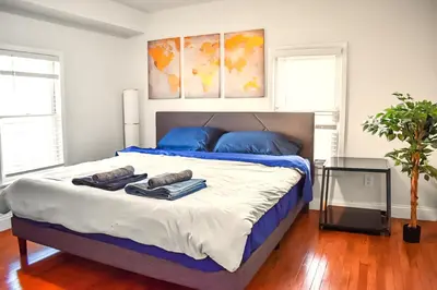 a bedroom with a bed with two towels on it at Spacious Cozy Retreat, Sleeps 10, Near NYC & EWR in Newark