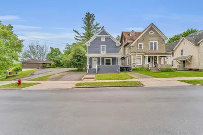 a row of houses on a street with a fire hydrant at Pitcher's Paradise Apt 3 All Star Baseball Rentals in Oneonta