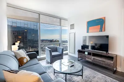 a living room with a couch and a tv at Luxury Modern Apt with Pool in Stamford