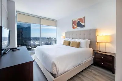 a bedroom with a bed and a desk with a television at Luxury Modern Apt with Pool in Stamford