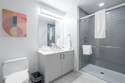 a white bathroom with a toilet and a shower at Luxury Modern Apt with Pool in Stamford