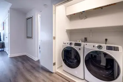 a white laundry room with a washer and dryer at Luxury Modern Apt with Pool in Stamford