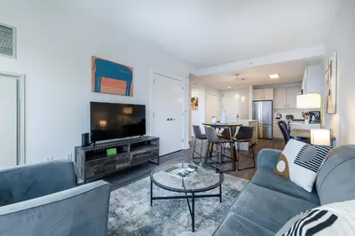a living room with a couch and a flat screen tv at Luxury Modern Apt with Pool in Stamford