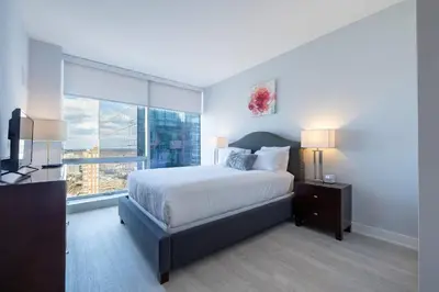 a bedroom with a bed and a large window at Chic Apt with Indoor Pool & Gym-333-2509 in New Rochelle