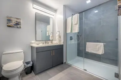 a bathroom with a shower and a toilet and a sink at Chic Apt with Indoor Pool & Gym-333-2509 in New Rochelle