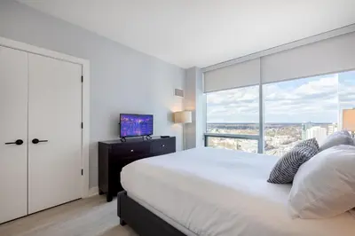 a bedroom with a bed and a large window at Chic Apt with Indoor Pool & Gym-333-2509 in New Rochelle