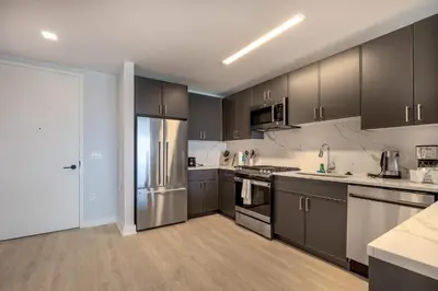 a kitchen with gray cabinets and stainless steel appliances at Chic Apt with Indoor Pool & Gym-333-2509 in New Rochelle