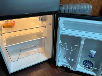 an open refrigerator with a bottle of water in it at Large and spacious room facing a beautiful park minutes away from Manhattan in High Bridge