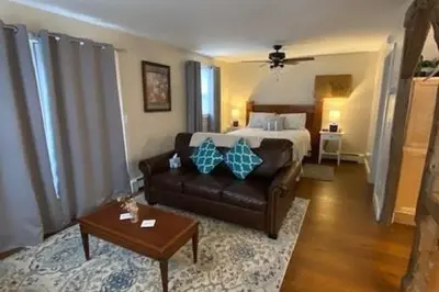 a living room with a bed and a couch at Cozy Cottage in the Catskills! in Oak Hill