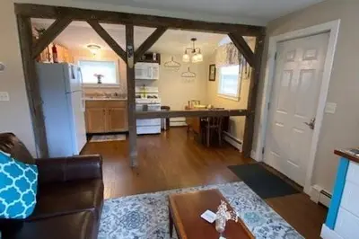 a living room with a table and a kitchen at Cozy Cottage in the Catskills! in Oak Hill