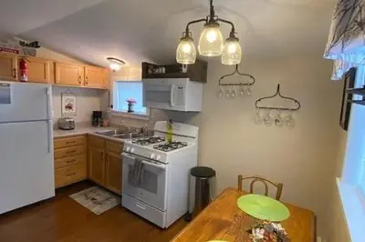 a kitchen with a white stove top oven next to a table at Cozy Cottage in the Catskills! in Oak Hill