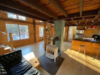 a living room with a fireplace in a log cabin at The Glow Room at Indian Hollow in Chesterfield