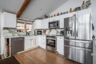 a kitchen with stainless steel appliances and white cabinets at Catskills Mountain Retreat - Luxury Meets Serenity in Jewett