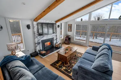 a living room with a blue couch and a fireplace at Catskills Mountain Retreat - Luxury Meets Serenity in Jewett
