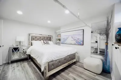 a white bedroom with a large bed and white walls at 3BR Private Apt near LGA, JFK, Manhattan, Northern Blvd in Jackson Heights