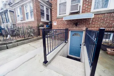 a blue door on the side of a brick building at 3BR Private Apt near LGA, JFK, Manhattan, Northern Blvd in Jackson Heights