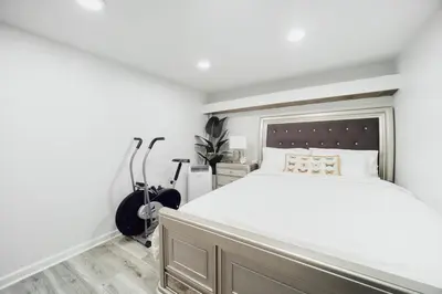 a bedroom with a large bed and two exercise bikes at 3BR Private Apt near LGA, JFK, Manhattan, Northern Blvd in Jackson Heights