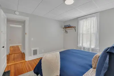 a bedroom with a blue bed and a window at West Hartford Center- Charming New England Apt in West Hartford