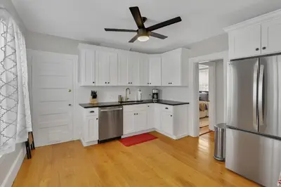 a kitchen with white cabinets and a ceiling fan at West Hartford Center- Charming New England Apt in West Hartford