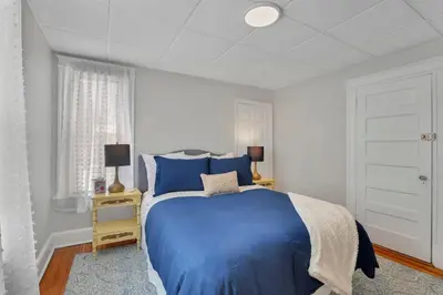 a bedroom with a blue bed and a window at West Hartford Center- Charming New England Apt in West Hartford