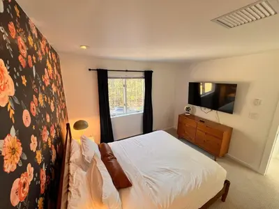 a bedroom with a bed and a dresser with a television at Luxury Woodstock Retreat Hot tub heated pool in Woodstock