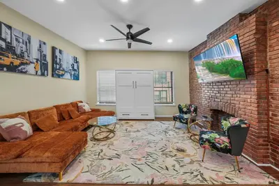 a living room with a couch and a brick fireplace at Free Parking -2BR,2Bath, 4Beds, Sleeps 6, 10 Min to NYC, 10 Min to Path in Hoboken