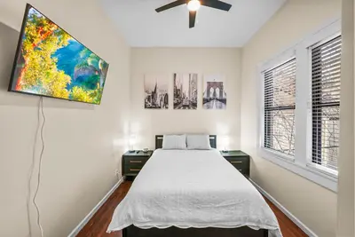 a bedroom with a bed and two windows at Free Parking -2BR,2Bath, 4Beds, Sleeps 6, 10 Min to NYC, 10 Min to Path in Hoboken