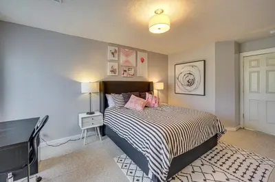 a bedroom with a bed with a black and white comforter at Spacious Modern Home about 1 Mi to Camelback Mountain! in Tannersville