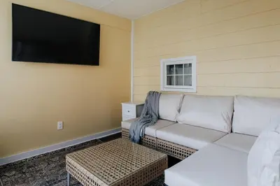 a living room with a couch and a flat screen tv at Majestic views Hot tub Firepit Games Sleeps 14 in Hillsdale