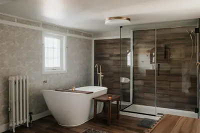 a bathroom with a tub and a glass shower at Majestic views Hot tub Firepit Games Sleeps 14 in Hillsdale