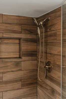 a shower in a bathroom with a wooden wall at Majestic views Hot tub Firepit Games Sleeps 14 in Hillsdale