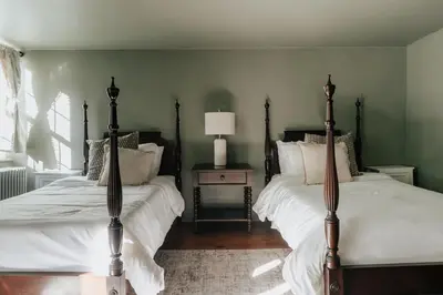 a bedroom with two beds and a table with a lamp at Majestic views Hot tub Firepit Games Sleeps 14 in Hillsdale