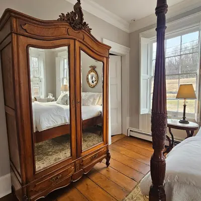 a bedroom with a large mirror and a bed at Peach Grove House in Warwick