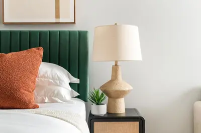 a lamp sitting on a table next to a bed at 73-812 New Studio UWS Doorman Gym in New York