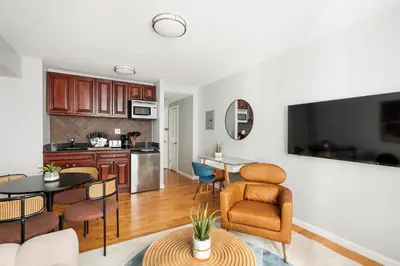 a kitchen and living room with a table and chairs at 73-806 New 1BR 1Bth UWS Doorman Gym in New York