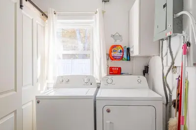 a laundry room with two white washers and a window at The Meyer spacious family home with hot tub in New Paltz