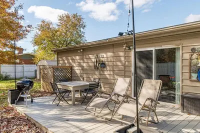 a patio with chairs and a table and a grill at The Meyer spacious family home with hot tub in New Paltz