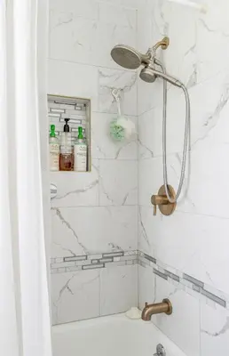 a bathroom with a shower with a white marble wall at The Yuzu stunning mountain retreat with hot tub in Gardiner
