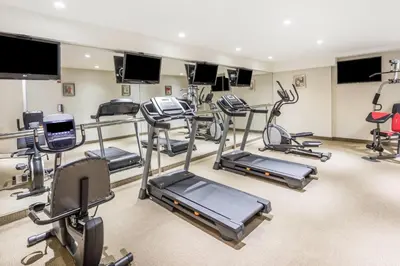 a gym with several treadmills and exercise equipment at Ramada by Wyndham Flushing Queens in Queens