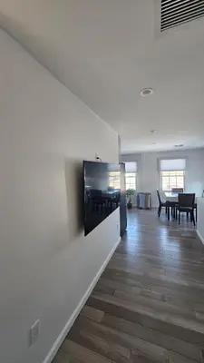 a living room with a flat screen tv on a wall at 3 Bedroom Renovated Model House in New Hyde Park