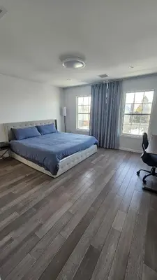 a bedroom with a bed and a wooden floor at 3 Bedroom Renovated Model House in New Hyde Park