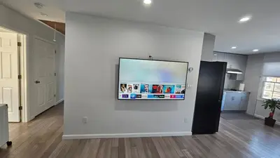 a living room with a flat screen tv on a wall at 3 Bedroom Renovated Model House in New Hyde Park