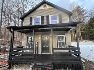 a tiny house with a black exterior at Twin Pines Lake Resort 1 in Northville