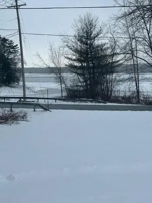 a snow covered road with a bench and a field at Twin Pines Lake Resort 1 in Northville