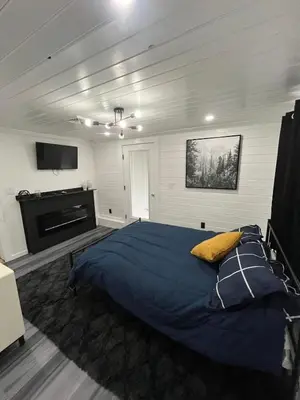a bedroom with a large bed and a flat screen tv at Twin Pines Lake Resort 1 in Northville