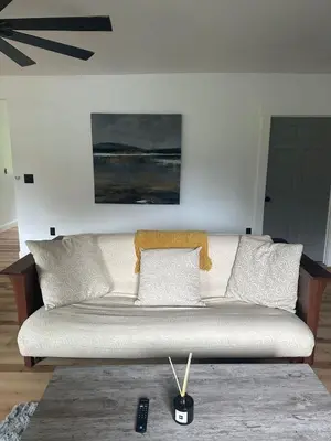 a white couch in a living room with a remote control at Twin Pines Lake resort 2 in Northville
