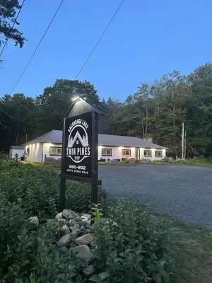 a sign in the grass in front of a house at Twin Pines Lake resort 2 in Northville