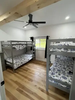 a room with three bunk beds and a ceiling fan at Twin pines 3 in Northville