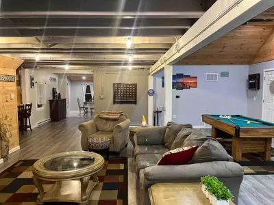 a living room with a couch and a pool table at Brooks bay in Lake Luzerne